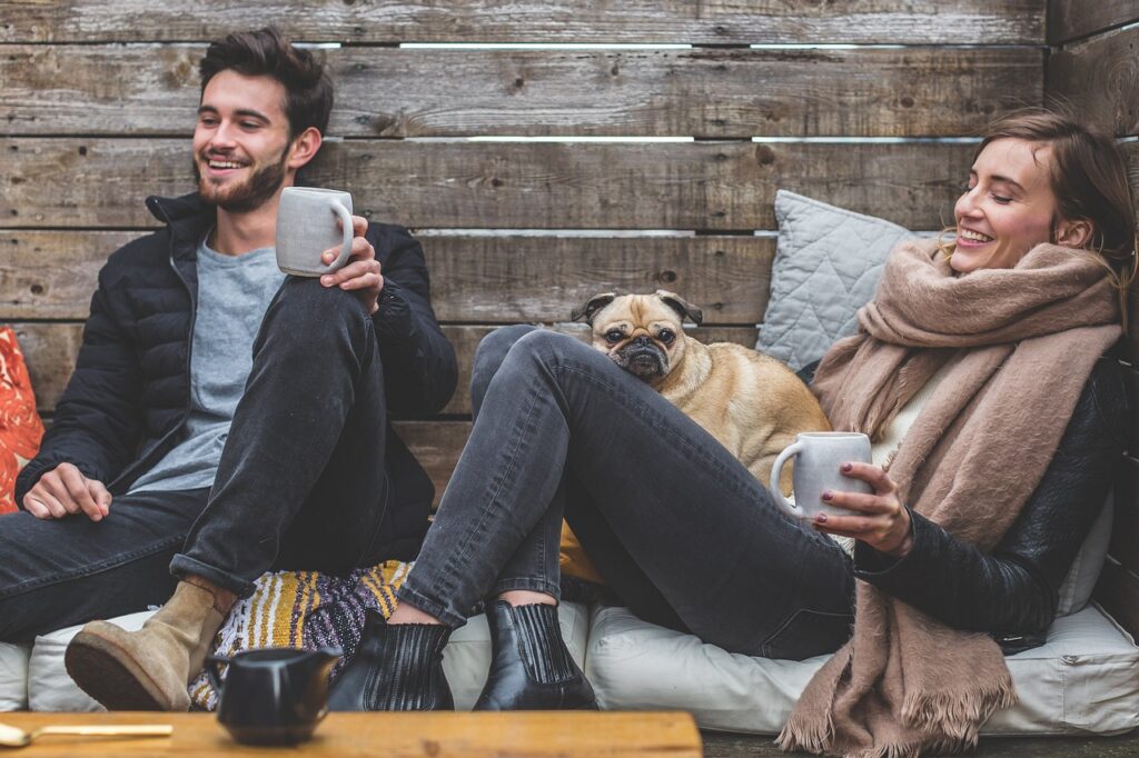 merry christmas, man, woman, dog, pet, pug, owners, couple, relationship, warm clothes, cozy, scarf, jackets, jeans, boots, fashion, people, happy, love, female, young, male, adult, caucasian, happiness, romantic, portrait, smile, smiling, girlfriend, date, boyfriend, together, person, animal, lovers, sitting, relaxing, rustic, cushions, couch, laughing, enjoying, coffee